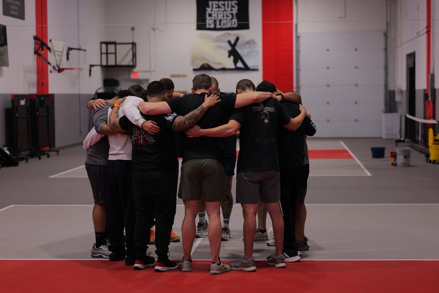 Men in a prayer huddle at The Forge